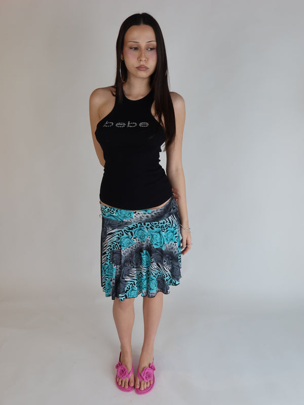 Authentic vintage Y2K mesh mini skirt with a mixed print of teal roses, leopard spots, and zebra stripes, featuring a low-rise waistband and lettuce-edge hem.