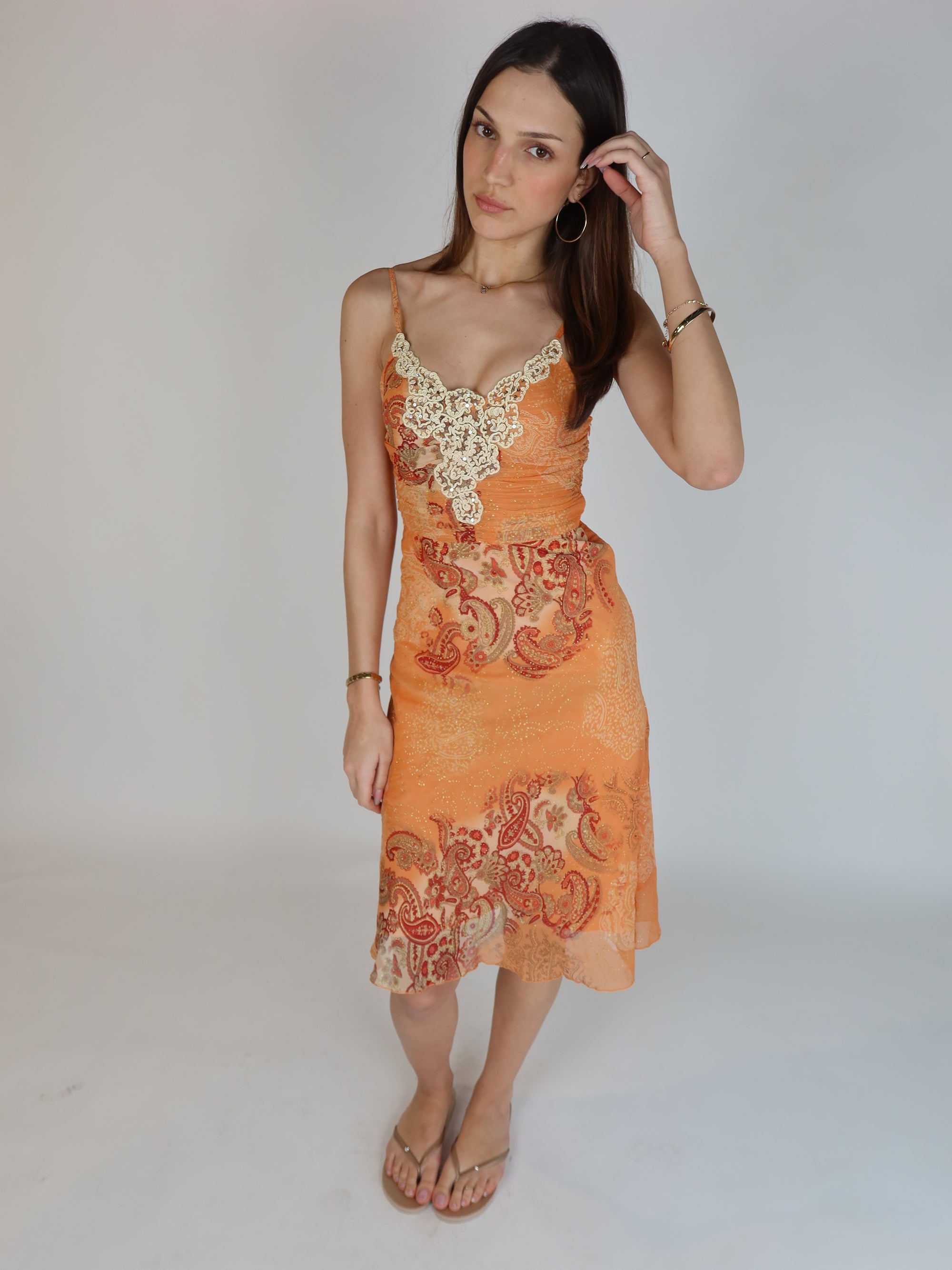 Vintage Y2K orange paisley slip dress with cream lace appliqué neckline, spaghetti straps, subtle shimmer details, and midi-length silhouette.