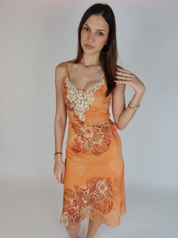 Vintage Y2K orange paisley slip dress with cream lace appliqué neckline, spaghetti straps, subtle shimmer details, and midi-length silhouette.