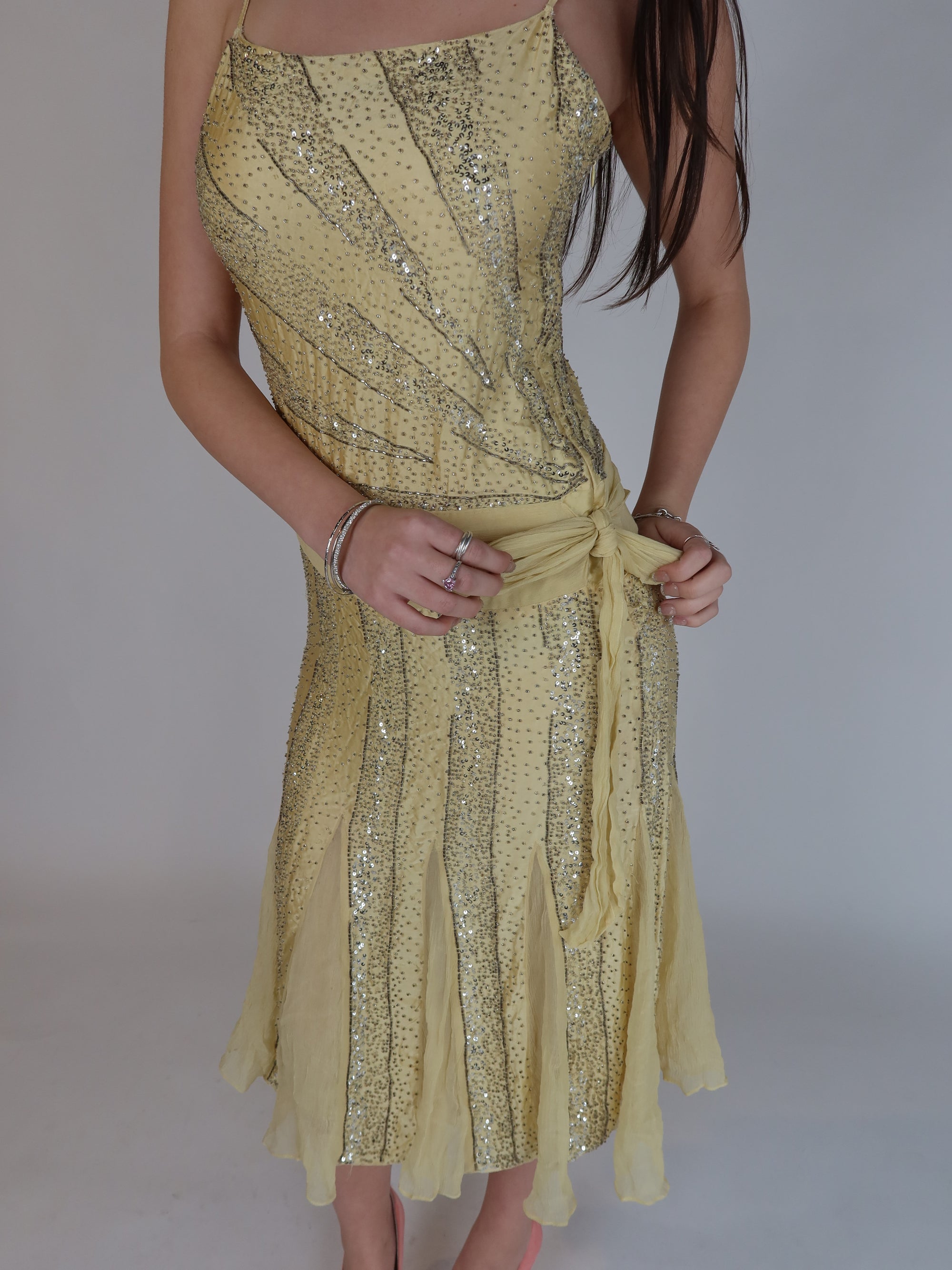 Vintage Y2K 100% silk beaded evening dress with intricate silver embellishments, spaghetti straps, matching waist tie, and handkerchief hem skirt.