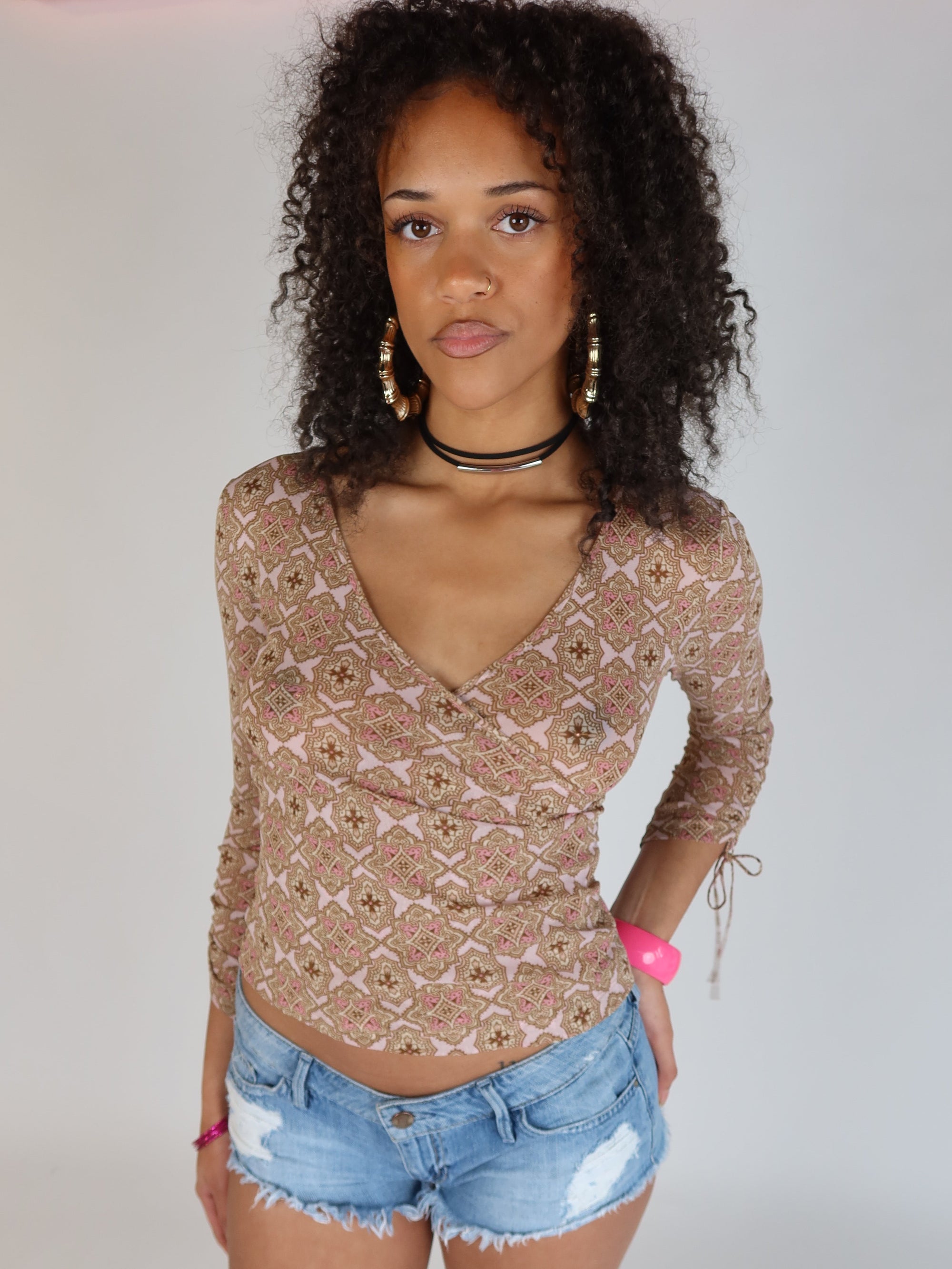 Vintage Y2K pink and brown geometric print mesh wrap top with long sleeves, V-neckline, and adjustable tie sleeve details.
