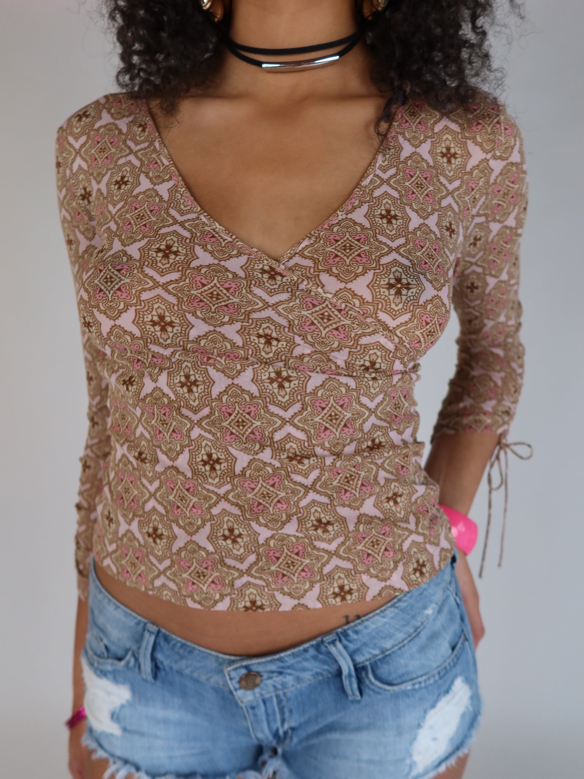 Vintage Y2K pink and brown geometric print mesh wrap top with long sleeves, V-neckline, and adjustable tie sleeve details.