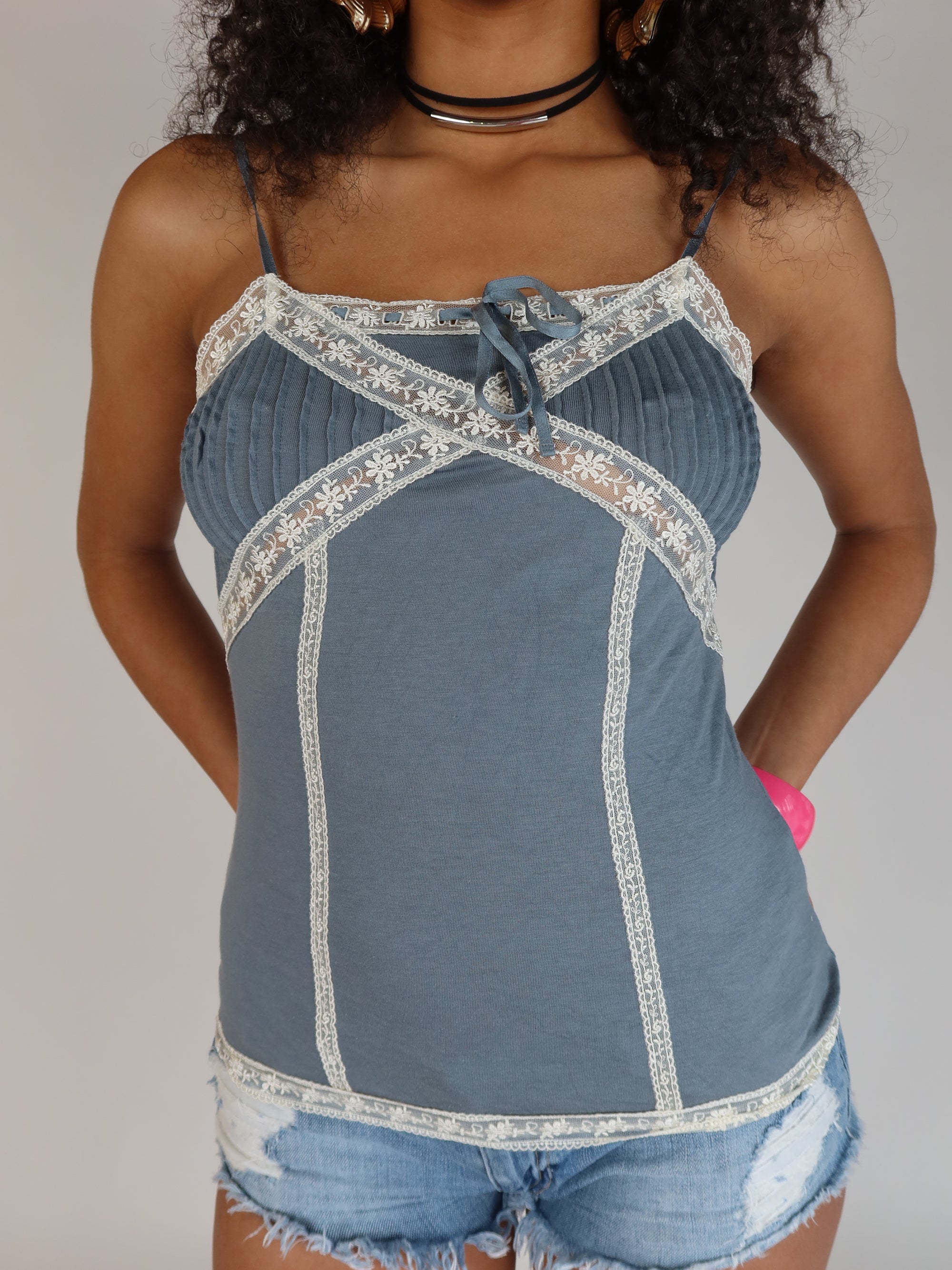 Vintage Y2K dusty blue camisole with cream lace trim, pintuck bust detailing, satin ribbon bow, adjustable spaghetti straps, and a fitted silhouette.