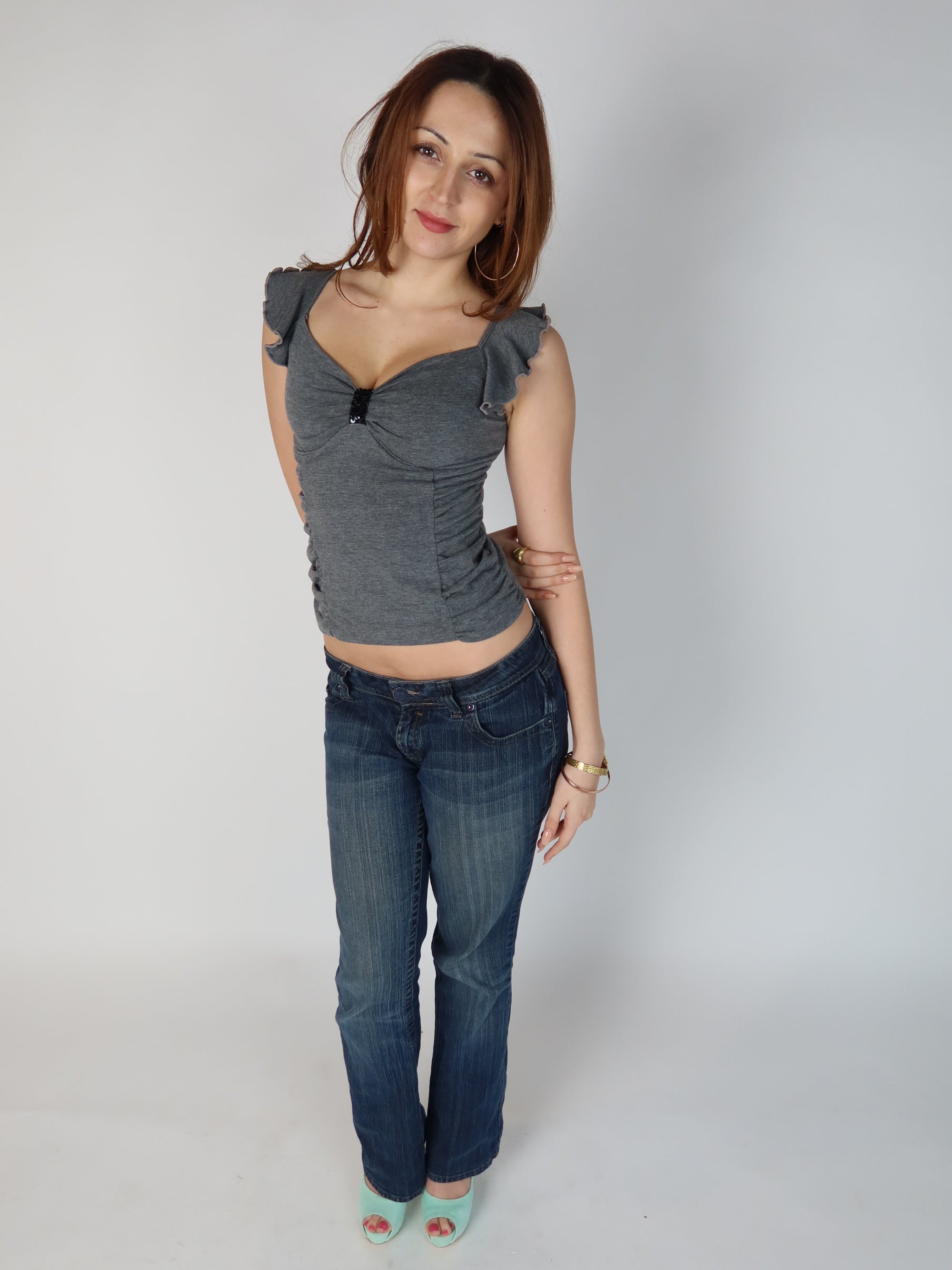 Authentic vintage Y2K grey cap-sleeve top with side ruching, sweetheart neckline, and black beaded chest embellishment, shown from front and back views with low-rise jeans.