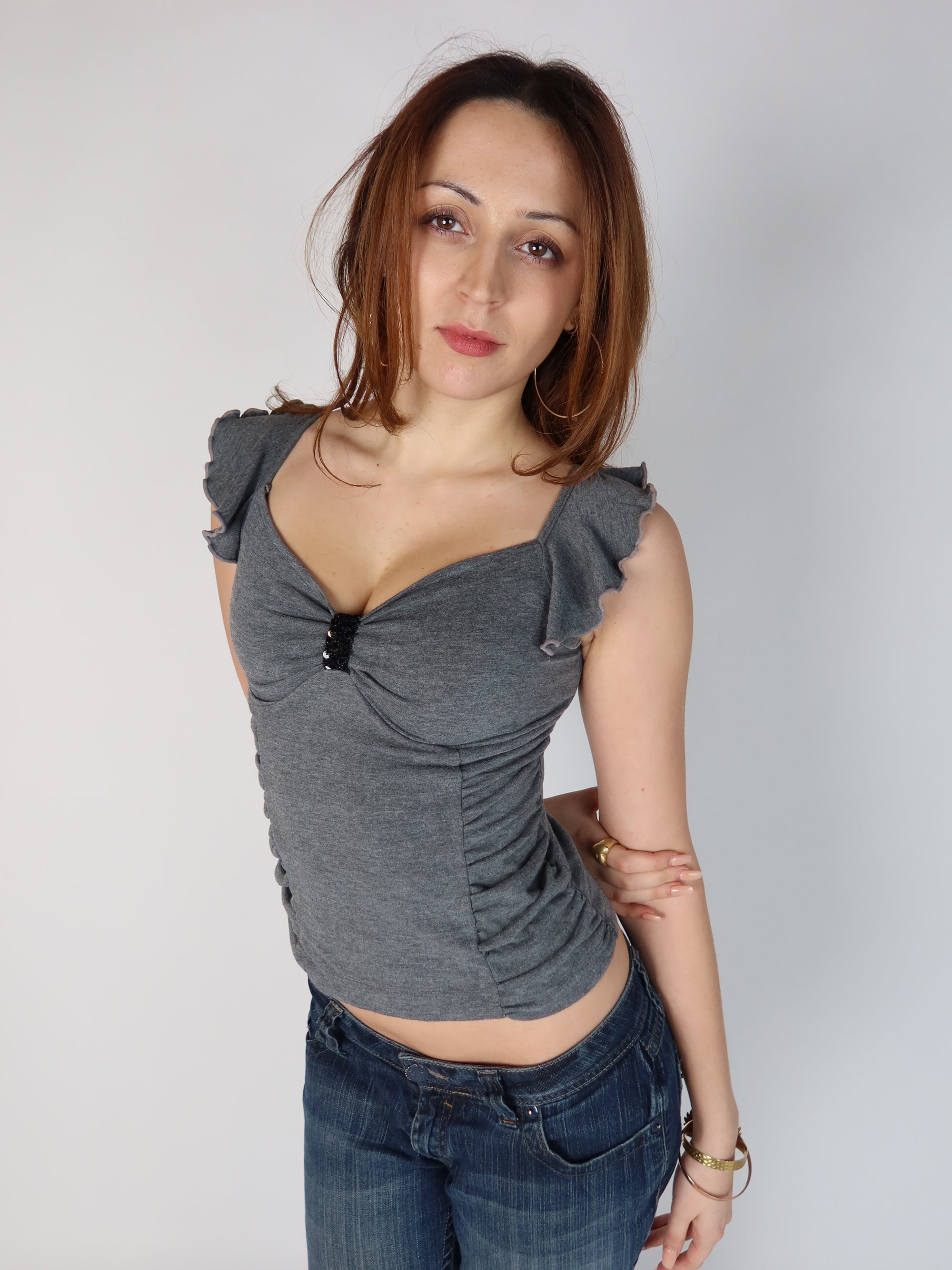 Authentic vintage Y2K grey cap-sleeve top with side ruching, sweetheart neckline, and black beaded chest embellishment, shown from front and back views with low-rise jeans.
