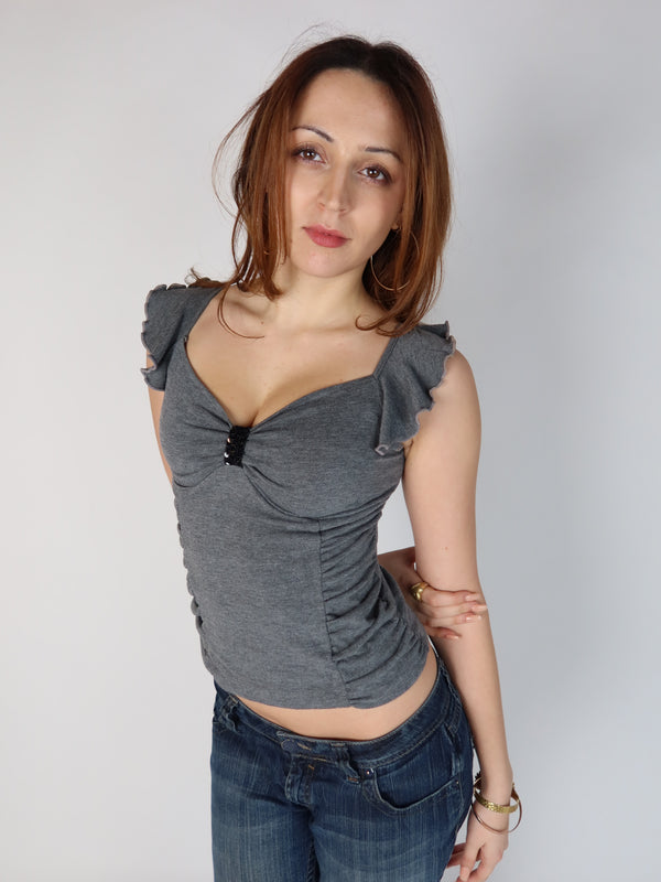 Authentic vintage Y2K grey cap-sleeve top with side ruching, sweetheart neckline, and black beaded chest embellishment, shown from front and back views with low-rise jeans.