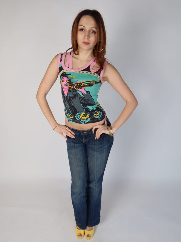 Authentic vintage Y2K teal and pink graphic tank top with a pop art trumpet girl print and pink multi-strap cut out shoulders, shown from front and back views with low-rise jeans.
