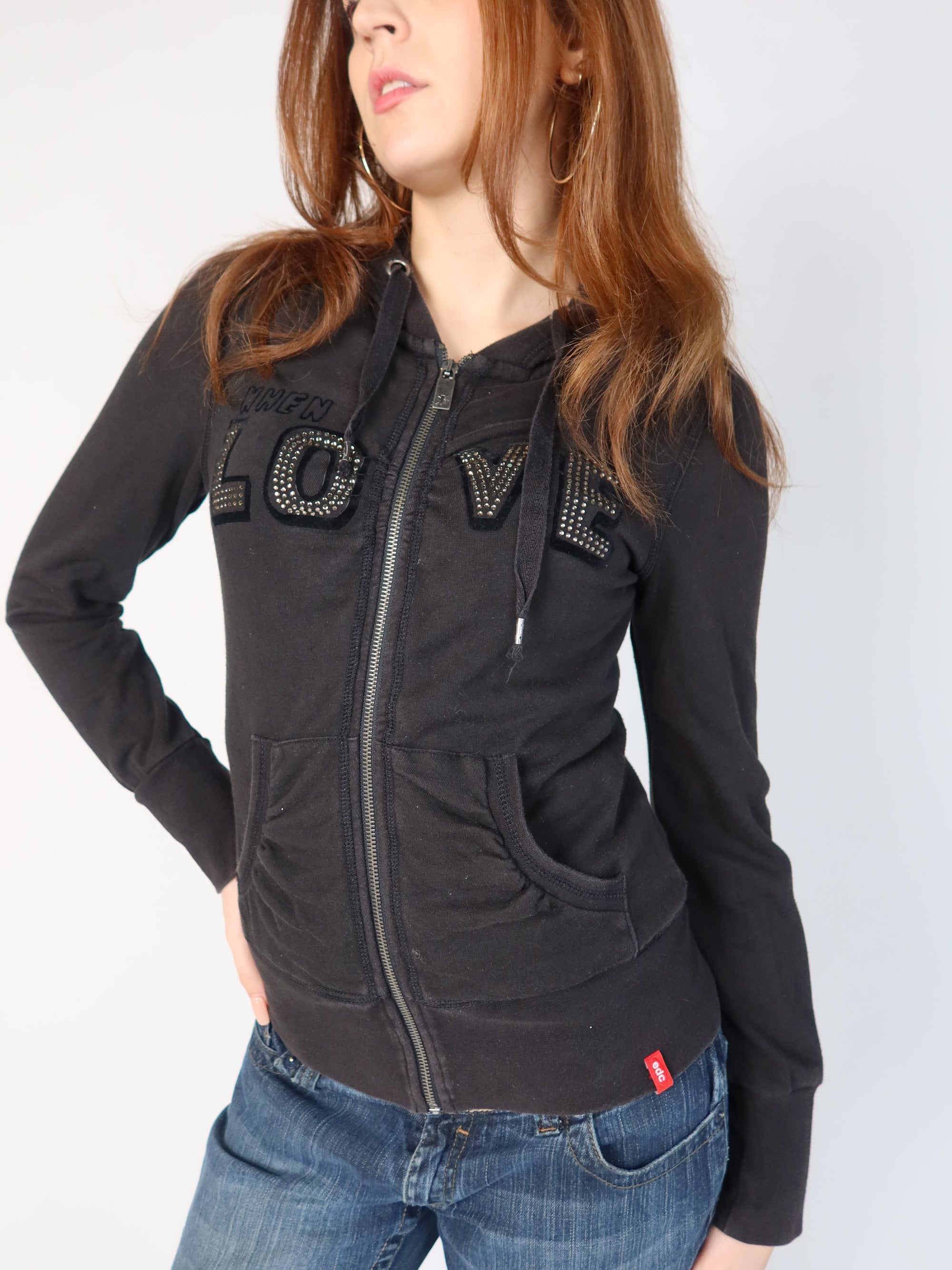 Authentic vintage Y2K EDC by Esprit black zip-up hoodie featuring a studded "LOVE" applique across the front chest and a black velvet textured "...COMES AROUND" graphic on the back, shown from front and back views with low-rise jeans.